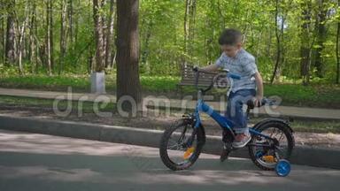 五岁的男孩在春天公园里骑一辆蓝色自行车